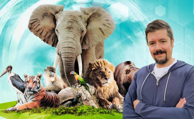 A photo of game designer Mathias Wiggle stands in front of a group of animals